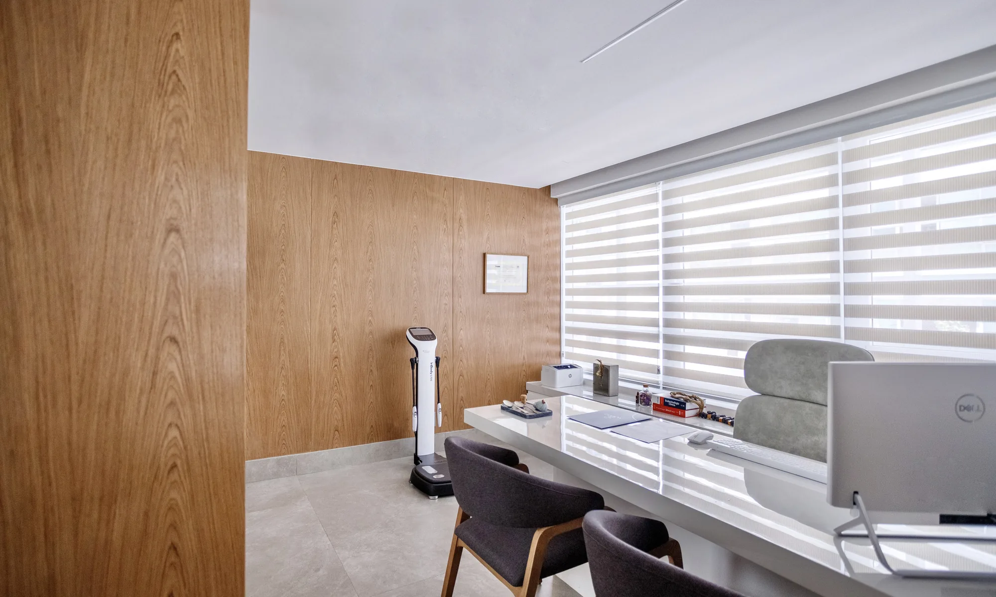 Consultation room at Clínica Almaaz with wood panelling and body composition scale