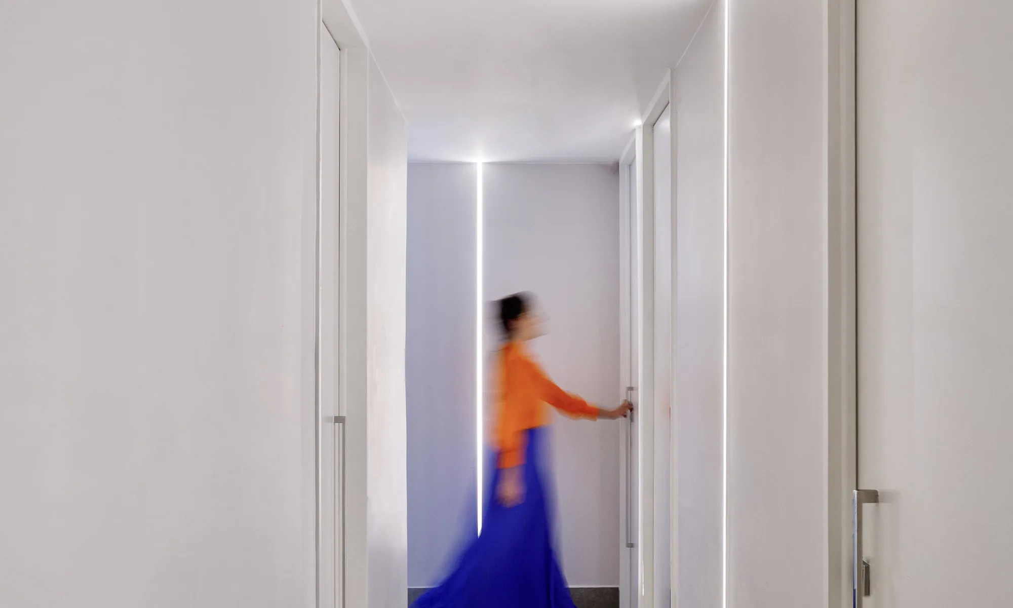 Patient walking down the white corridor to the treatment rooms at Clínica Almaaz